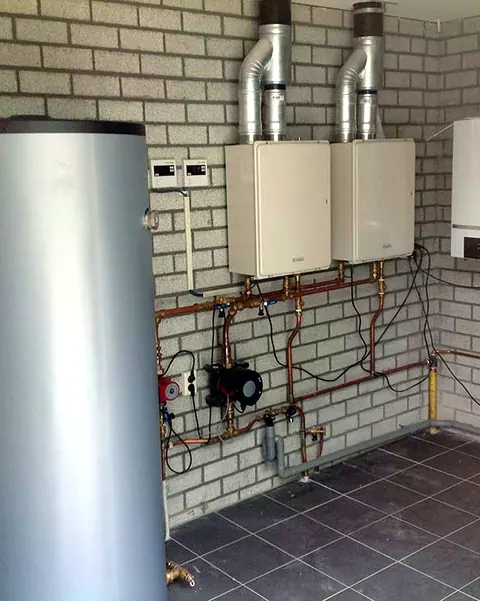 Technische ruimte met boilervat, ketels en koperen leidingwerk